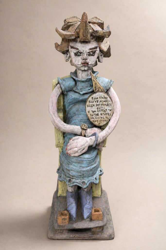 Standing girl holding a round sign. Ceramic sculpture by Ted Fullwood