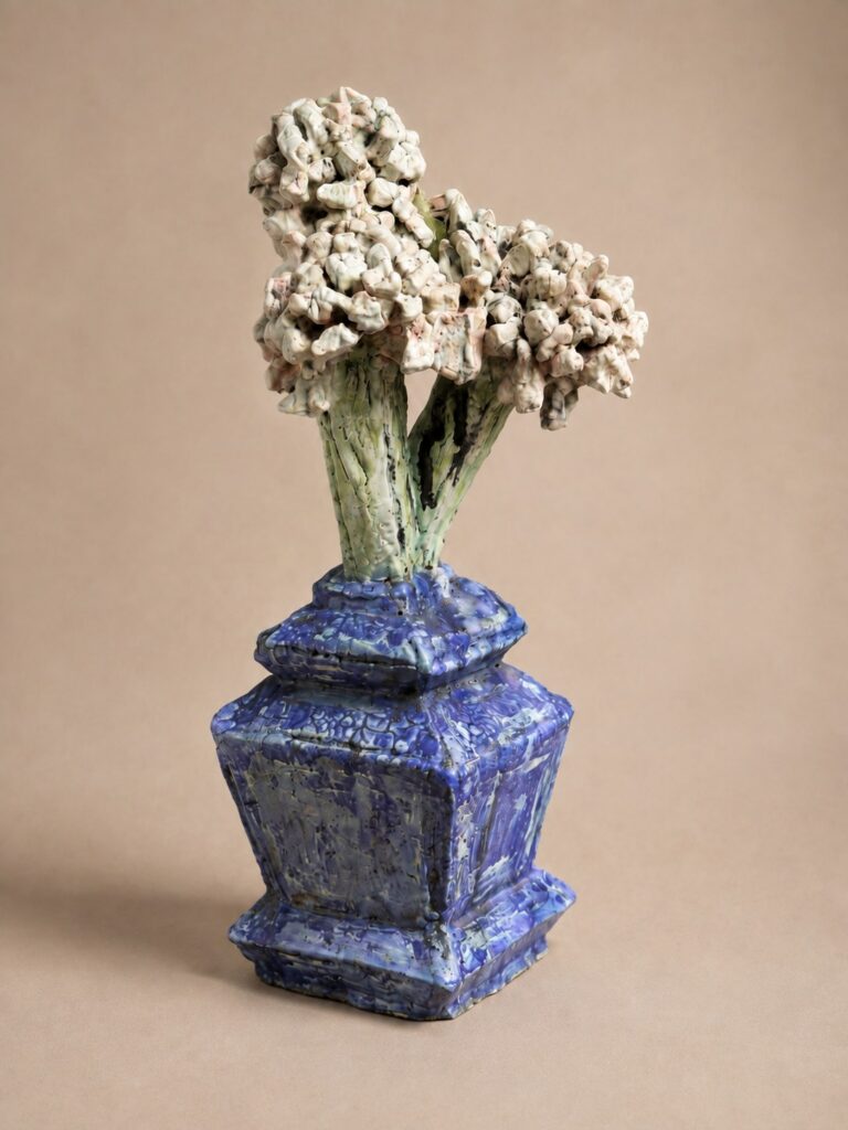 White blossoms in a cobalt blue vase. Ceramic sculpture by Ted Fullwood