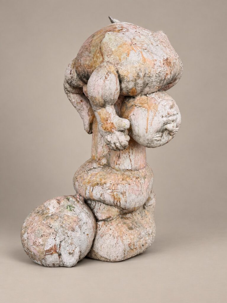 Stacked rounded figure with a ball at its foot. Ceramic sculpture by Ted Fullwood